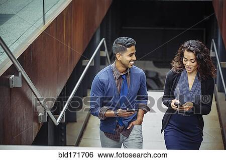 Stock Photograph - Business people using cell phones on office steps. Fotosearch