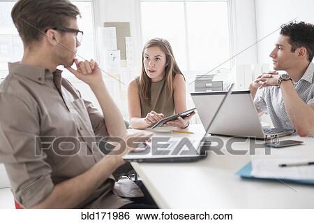 Business people using technology in office meeting View Large Photo Image Stock Photograph - Business people using technology in office meeting. Fotosearch