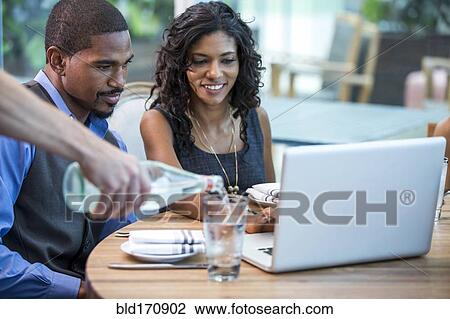 Stock Image - Business people working at lunch in cafe. Fotosearch