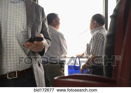 Businessman using cell phone in airport View Large Photo Image Stock Photo - Businessman using cell phone in airport. Fotosearch