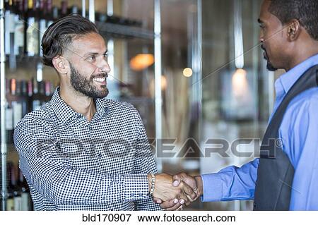 Businessmen shaking hands in restaurant View Large Photo Image Stock Photo - Businessmen shaking hands in restaurant. Fotosearch