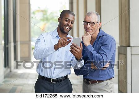 Stock Photography - Businessmen using cell phone in city. Fotosearch