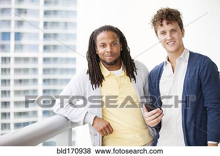 Businessmen using cell phone on urban balcony View Large Photo Image Stock Photo - Businessmen using cell phone on urban balcony. Fotosearch