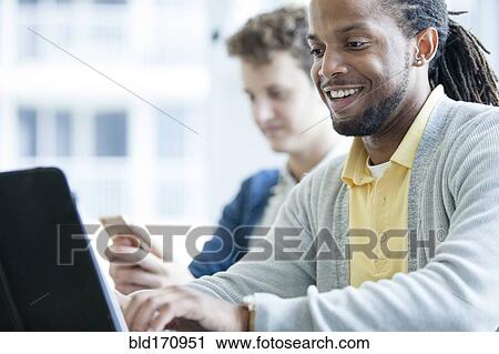 Businessmen using technology in office View Large Photo Image Stock Image - Businessmen using technology in office. Fotosearch