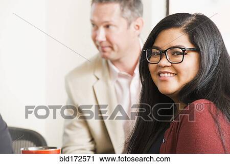 Businesswoman smiling in office meeting View Large Photo Image Stock Image - Businesswoman smiling in office meeting. Fotosearch
