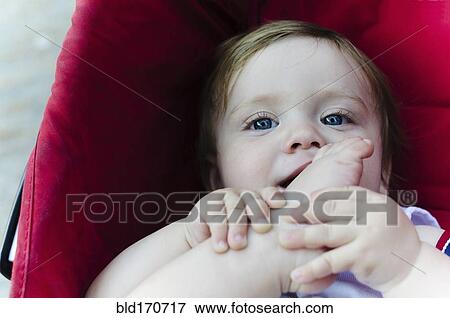 Stock Photo - Caucasian baby boy chewing his toes. Fotosearch