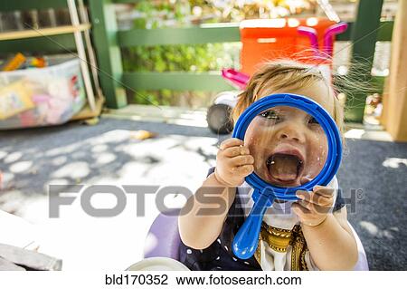 Stock Image - Caucasian baby girl playing on patio. Fotosearch
