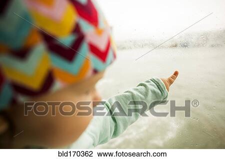 Caucasian baby girl pointing at ocean from window View Large Photo Image Stock Image - Caucasian baby girl pointing at ocean from window. Fotosearch