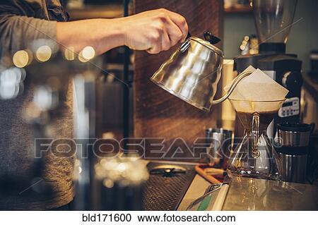 Caucasian barista pouring hot water over coffee in cafe View Large Photo Image Stock Image - Caucasian barista pouring hot water over coffee in cafe. Fotosearch