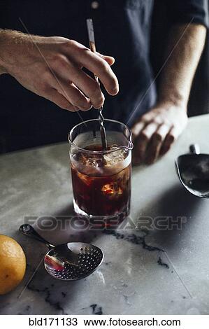 Caucasian bartender mixing cocktail in glass View Large Photo Image Stock Image - Caucasian bartender mixing cocktail in glass. Fotosearch