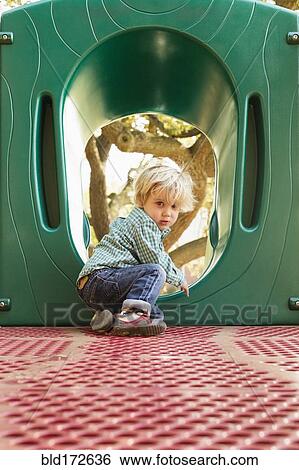 Stock Photograph - Caucasian boy climbing on play structure in playground. Fotosearch