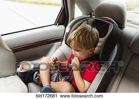 Caucasian boy eating snack in car seat View Large Photo Image Stock Image - Caucasian boy eating snack in car seat. Fotosearch