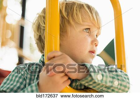 Stock Photo - Caucasian boy on play structure in playground. Fotosearch