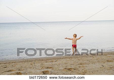 Stock Image - Caucasian boy playing on beach. Fotosearch