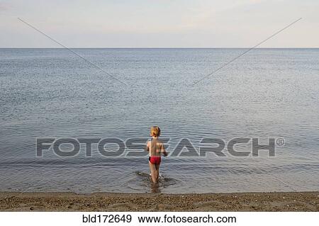 Stock Photo - Caucasian boy playing on beach. Fotosearch