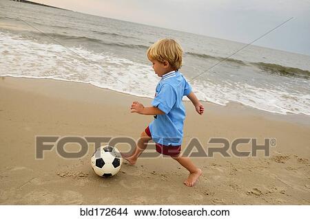 Caucasian boy playing with soccer ball on beach View Large Photo Image Picture - Caucasian boy playing with soccer ball on beach. Fotosearch