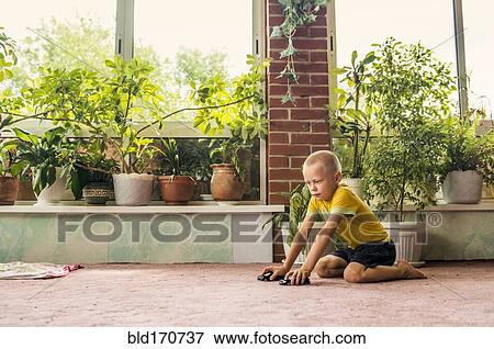 Caucasian boy playing with toy cars on floor View Large Photo Image Stock Photo - Caucasian boy playing with toy cars on floor. Fotosearch