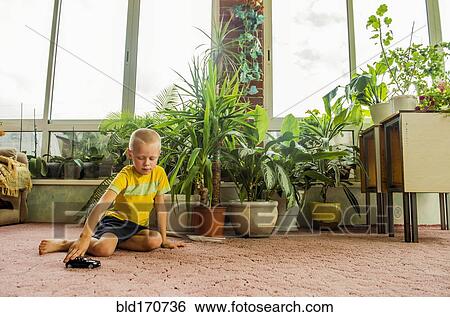 Caucasian boy playing with toy cars on floor View Large Photo Image Stock Photograph - Caucasian boy playing with toy cars on floor. Fotosearch
