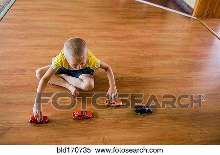 Caucasian boy playing with toy cars on floor View Large Photo Image Stock Photography - Caucasian boy playing with toy cars on floor. Fotosearch