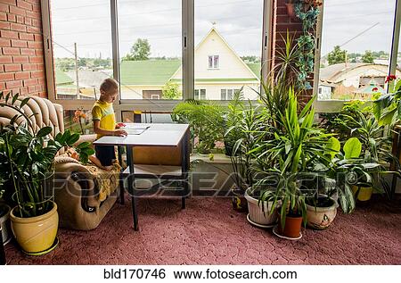 Stock Photograph - Caucasian boy reading magazine at desk. Fotosearch