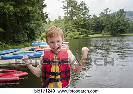 Caucasian boy wearing lifejacket by lake View Large Photo Image Stock Photo - Caucasian boy wearing lifejacket by lake. Fotosearch