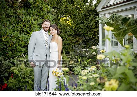 Picture - Caucasian bride and groom smiling in garden. Fotosearch