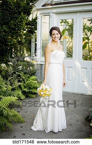 Caucasian bride holding bouquet in garden View Large Photo Image Stock Photo - Caucasian bride holding bouquet in garden. Fotosearch