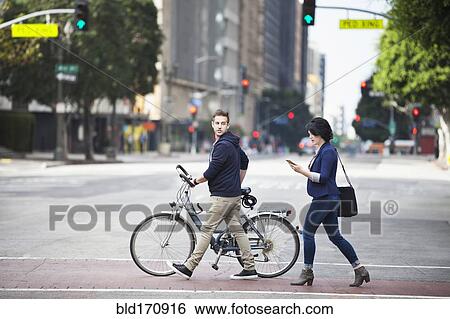 Stock Photograph - Caucasian business people crossing city street. Fotosearch