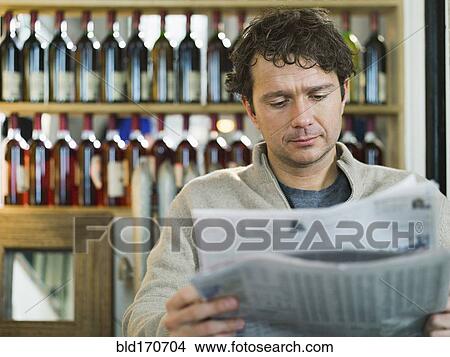 Picture - Caucasian businessman reading newspaper in restaurant. Fotosearch