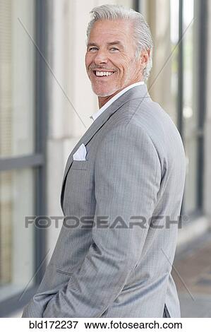 Stock Photo - Caucasian businessman smiling in city. Fotosearch