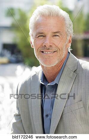 Caucasian businessman smiling in city View Large Photo Image Stock Photograph - Caucasian businessman smiling in city. Fotosearch