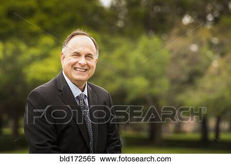 Stock Photography - Caucasian businessman smiling in park. Fotosearch