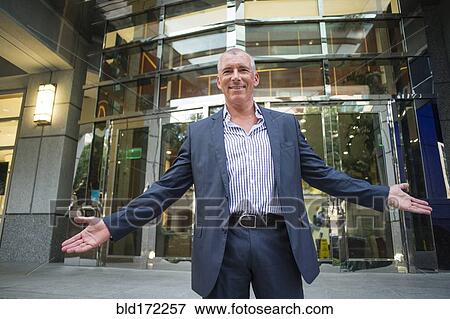 Stock Photo - Caucasian businessman standing outside office building. Fotosearch