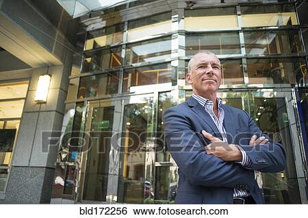 Stock Photograph - Caucasian businessman standing outside office building. Fotosearch