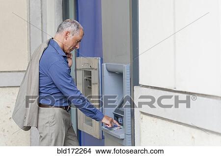 Caucasian businessman using ATM View Large Photo Image Picture - Caucasian businessman using ATM. Fotosearch