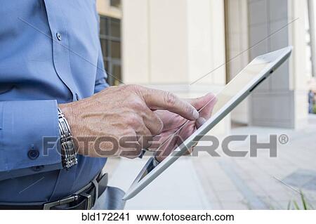Stock Image - Caucasian businessman using digital tablet. Fotosearch