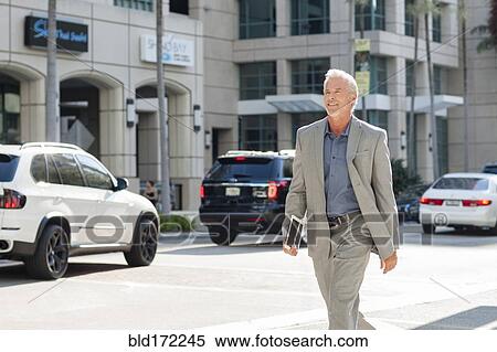 Stock Photography - Caucasian businessman walking in city. Fotosearch