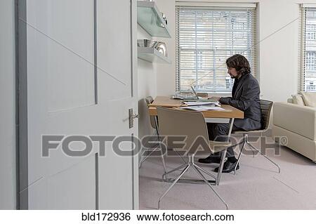 Caucasian businessman working at home office View Large Photo Image Stock Photograph - Caucasian businessman working at home office. Fotosearch