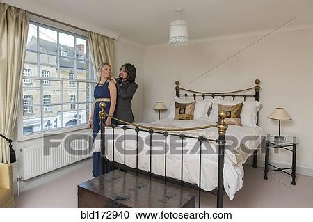 Stock Image - Caucasian couple dressing in bedroom. Fotosearch