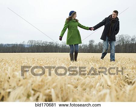 Caucasian couple holding hands in rural field View Large Photo Image Stock Image - Caucasian couple holding hands in rural field. Fotosearch