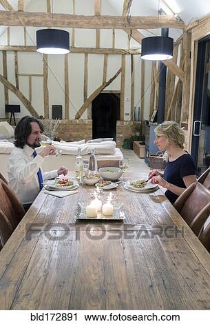 Caucasian couple in dining room of converted barn home View Large Photo Image Stock Image - Caucasian couple in dining room of converted barn home. Fotosearch