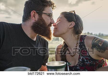 Caucasian couple kissing at picnic table View Large Photo Image Stock Image - Caucasian couple kissing at picnic table. Fotosearch