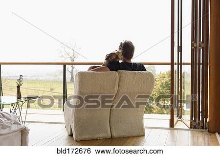 Stock Photograph - Caucasian couple lounging on balcony. Fotosearch