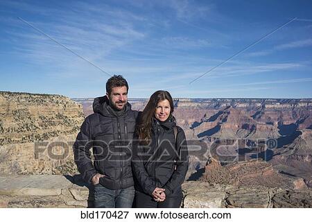 Stock Photo - Caucasian couple standing over Grand Canyon, Arizona, United States. Fotosearch