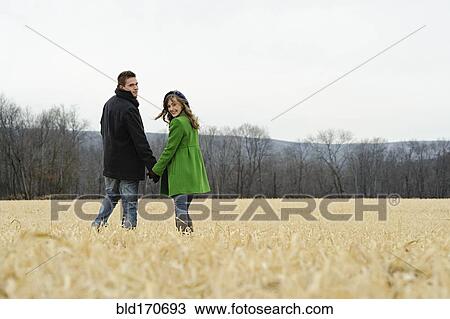 Caucasian couple walking in rural field View Large Photo Image Stock Image - Caucasian couple walking in rural field. Fotosearch