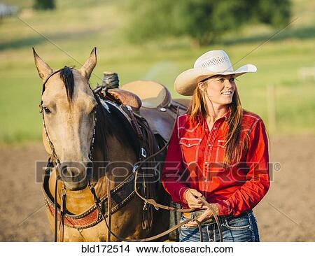 Caucasian cowgirl walking horse on ranch View Large Photo Image Picture - Caucasian cowgirl walking horse on ranch. Fotosearch