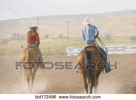 Caucasian cowgirls riding horses on ranch View Large Photo Image Stock Photograph - Caucasian cowgirls riding horses on ranch. Fotosearch