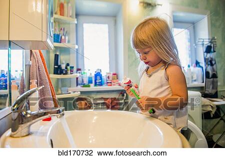 Caucasian girl brushing her teeth in bathroom View Large Photo Image Stock Image - Caucasian girl brushing her teeth in bathroom. Fotosearch