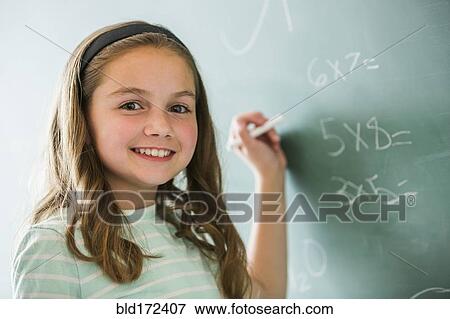 Stock Photo - Caucasian girl doing math problems on chalkboard. Fotosearch