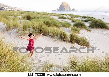 Caucasian girl running with arms outstretched on beach View Large Photo Image Stock Photo - Caucasian girl running with arms outstretched on beach. Fotosearch